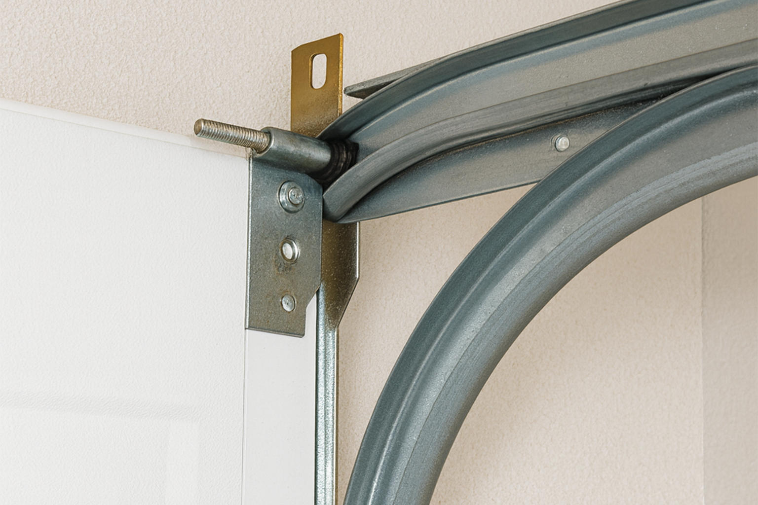 Close-up view of garage door track section with curved metal rail and hinge bracket