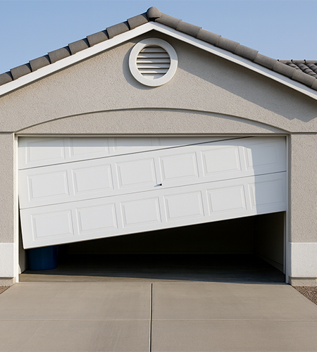 Garage door off track and misaligned at a residential house, showing tilted panels